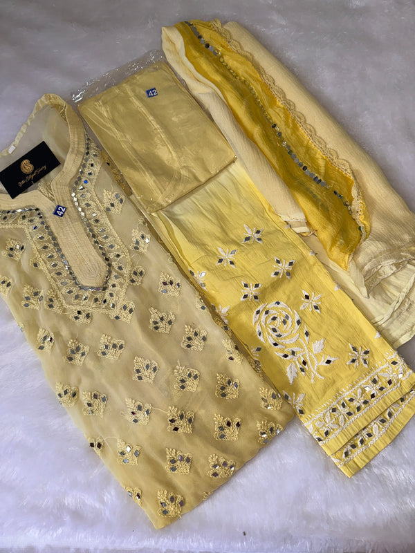A yellow ombre Chikankari Mirror suit with embroidery, consisting of a kurta, inner, bottom, and dupatta, displayed on a white surface.